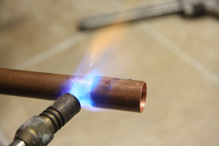 Avant d'appliquer la soudure, le joint est chauffé avec un brûleur à gaz Flux pour le brasage des tuyaux en cuivre