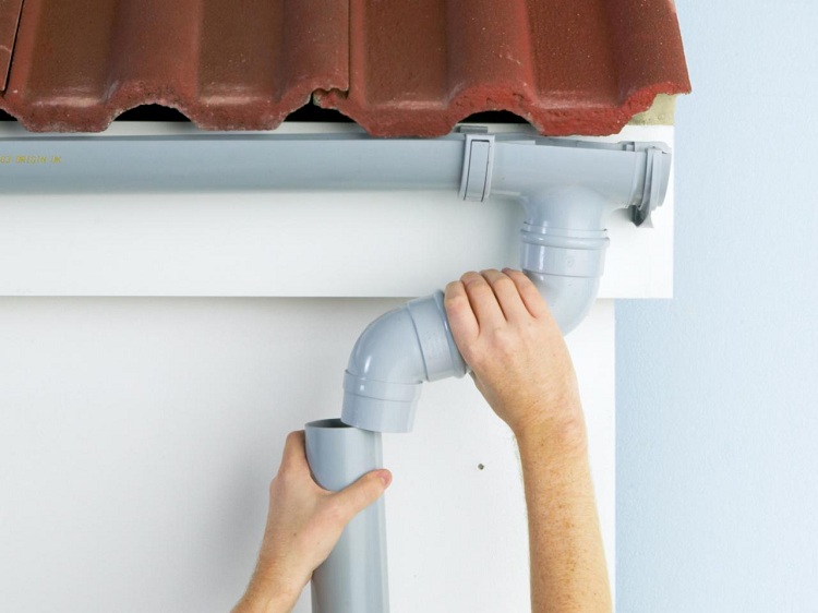 La partie verticale du drain est montée après l'installation de gouttières horizontales Égoutter des tuyaux d'égout bricolage
