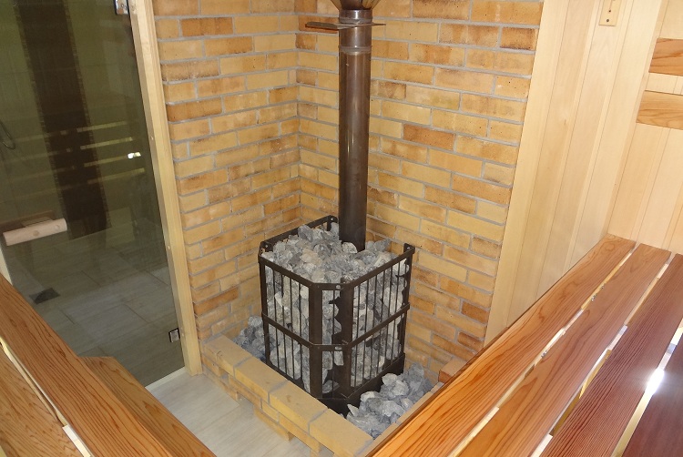 Une grille autour de la cheminée remplie de pierres est aussi une sorte d'échangeur de chaleur. Échangeur de chaleur de tuyau de cheminée