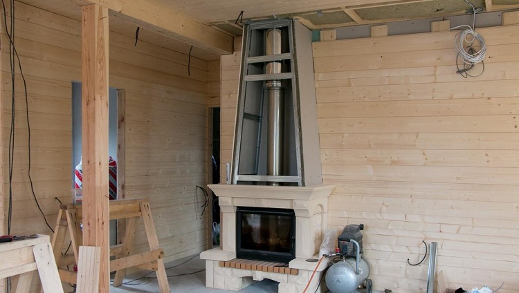 À l'intérieur de la maison, la cheminée peut être cachée sous un cadre en cloison sèche, résistant aux températures élevées Garniture de cheminée de toit