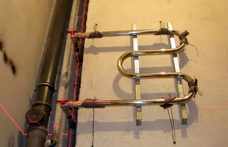 Souvent, un porte-serviettes chauffant est situé à côté de la colonne montante d'ECS, mais à l'aide de tuyaux, vous pouvez l'installer et loin du tuyau principal Connexion serviette